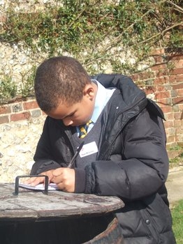 Student writing in a notebook at Down House
